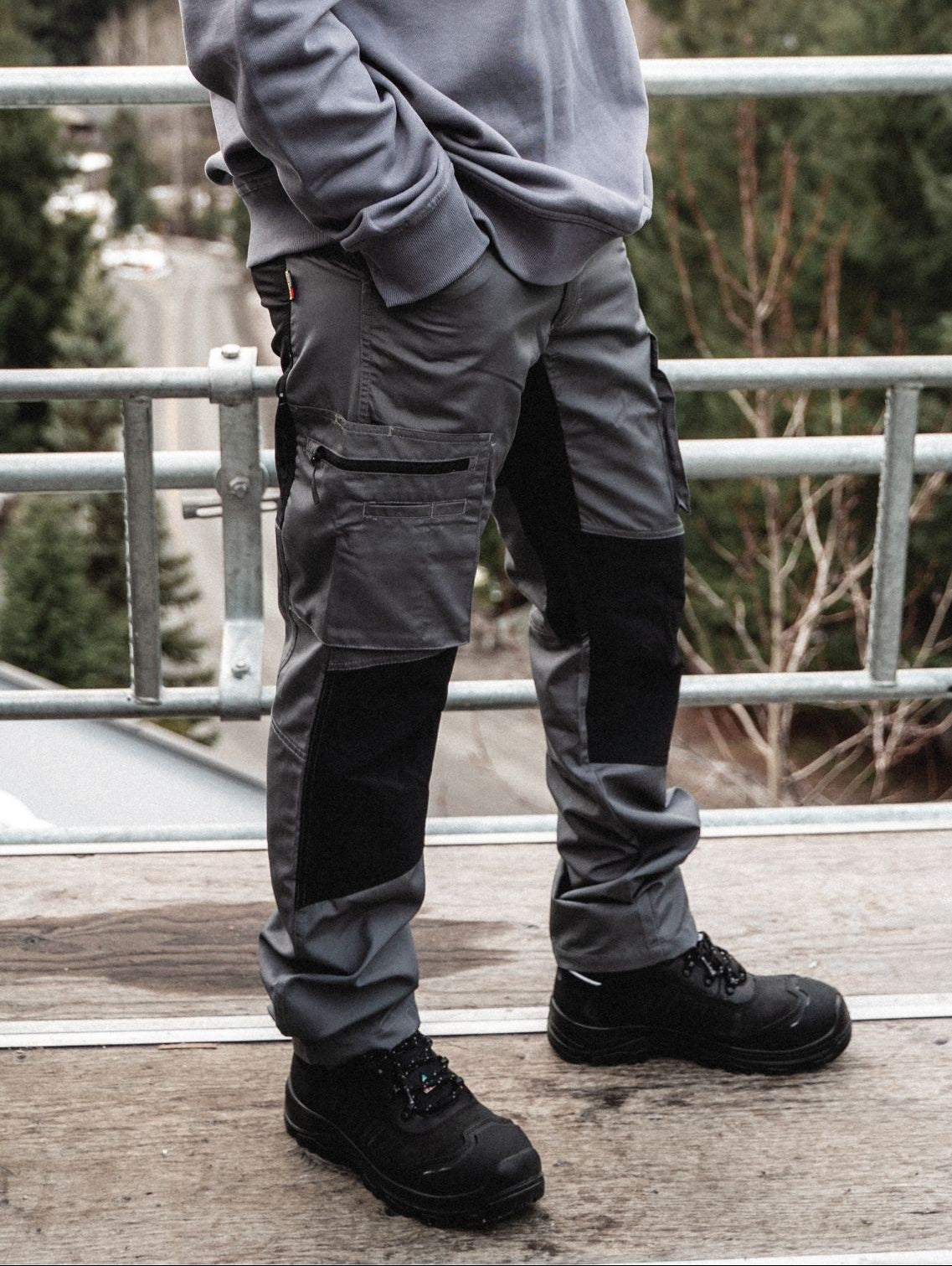 Blaklader Service Pants with Stretch in Grey worn by tradesperson standing on scaffolding at outdoor job site