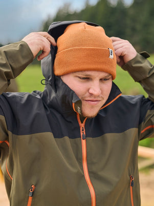 Blaklader Cascade Jacket in Forest Green Rust with adjustable hood worn by tradesperson on outdoor job site